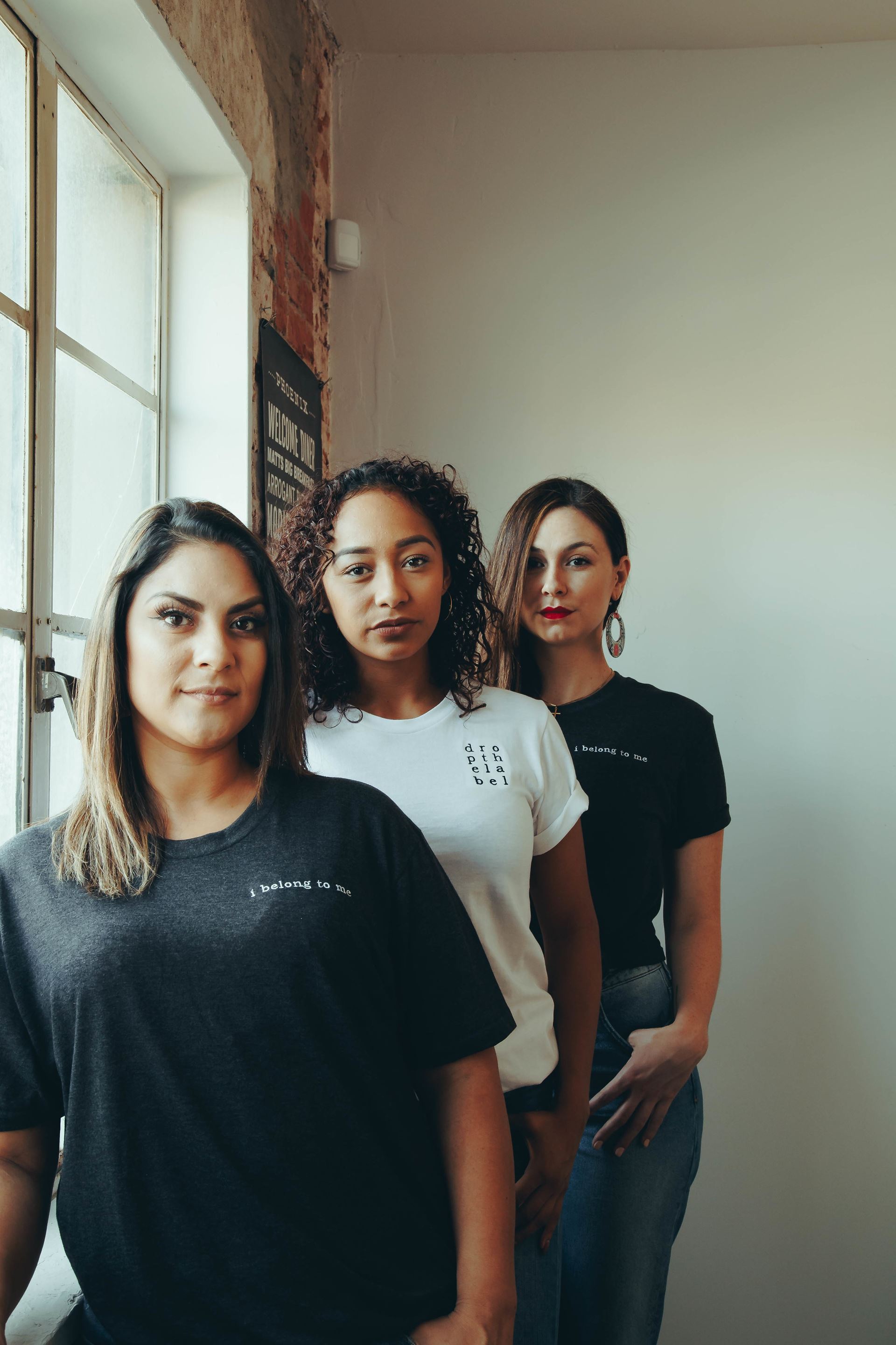 a group of women standing next to a window